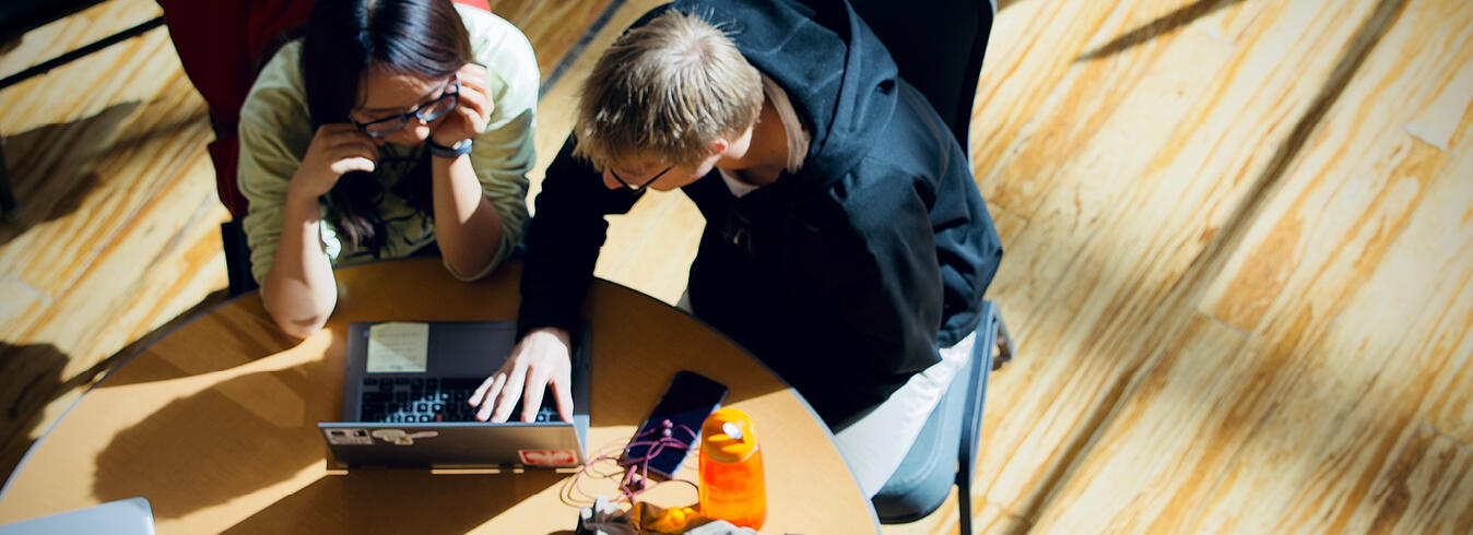 Master of Accounting Science Common Questions Hero Photo Two students leaning over a computer at a table